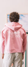 Man with a pink sweater with art wall
