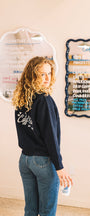 Girl wearing Early Bird Coffee Club zip sweatshirt in Buen dia coffee with a cup of coffee