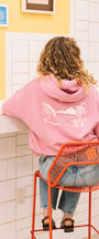 Woman sitting in a coffee shop with a pink hoodie in san luis obispo