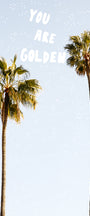 A photographic print featuring two palm trees against a blue sky with the sun setting in the background, and the text 'YOU ARE GOLDEN' overlaid at the top.